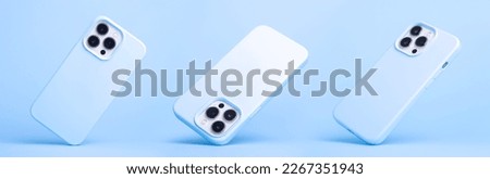 set of three iPhone 14 and 13 Pro Max in blue silicone case falling down in different angles, back view isolated on blue background, phone case mockup in monochrome colours