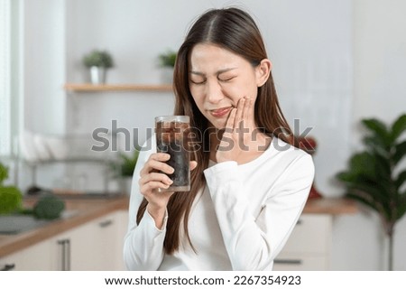 Health asian young woman touching her mouth, expression, suffering from toothache, decay or sensitivity cavity molar tooth or inflammation drink cold, sparkling water at home.Sensitive teeth people. Royalty-Free Stock Photo #2267354923