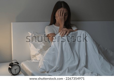 Can not sleep, depressed asian young woman, girl suffering sitting in bed from insomnia problem, awake at night, covering face with hand because of disturbed loud noise, unable sleep. Restless people. Royalty-Free Stock Photo #2267354971