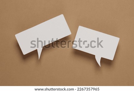 White blank paper-cut speech bubble on brown background. Chat, social media, discussion. Mock up for template design Royalty-Free Stock Photo #2267357965