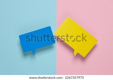 Different colors blank paper-cut speech bubbles on pink blue background. Chat, social media, discussion. Mock up for template design. Top view