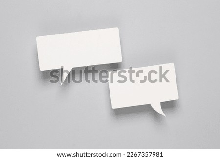 White blank paper-cut speech bubbles on gray background. Chat, social media, discussion. Mock up for template design