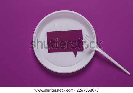 Speech bubble in a plastic plate with a fork on a purple background