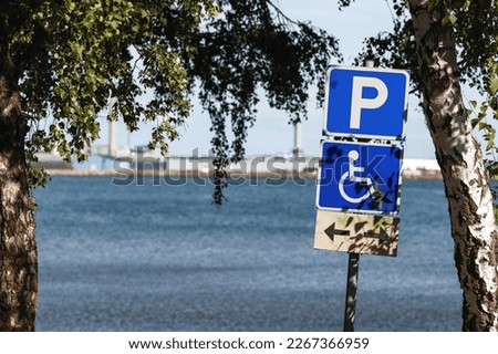 Reserved disabled parking space sign at Kattegat sea shoreline in Halmstad, Sweden. Selective focus.