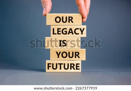 Legacy and future symbol. Concept words Our legacy is your future on wooden blocks. Beautiful grey table grey background. Businessman hand. Business legacy and future concept. Copy space.
