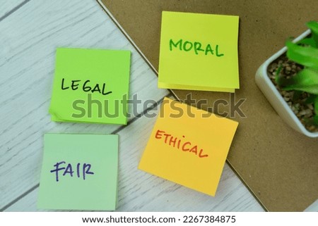 Concept of Legal, Moral, Fair, Ethical write on sticky notes isolated on Wooden Table.