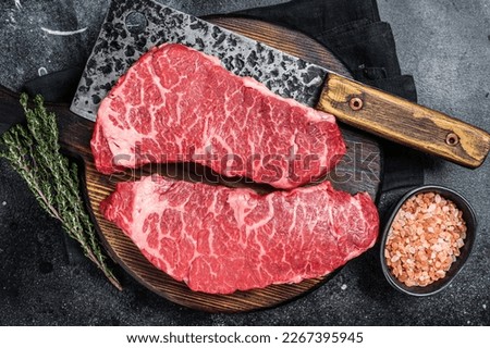 Marbled beef Denver raw meat steak with herbs. Black background. Top view. Royalty-Free Stock Photo #2267395945