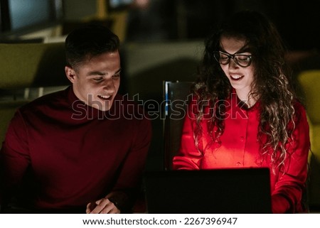 Lovely business couple working late night at the office and having fun conversation. Close up photo