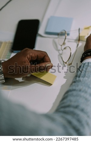 A close up photo of male person with sticky notes in his hands