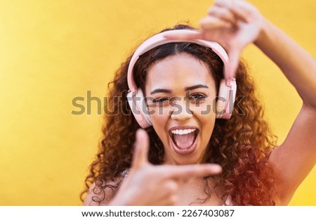 Hands, frame and portrait of woman with headphones on yellow background for profile picture. Face, female and finger framing with music for perspective, selfie and vision of happiness, smile and tech