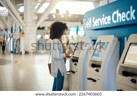 Black woman, airport and self service kiosk for check in, ticket registration or online boarding pass. African female traveler by terminal machine for travel application, document or booking flight Royalty-Free Stock Photo #2267403603