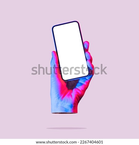 The hand holds a smartphone with a white screen. Art collage. Mockup. Royalty-Free Stock Photo #2267404601