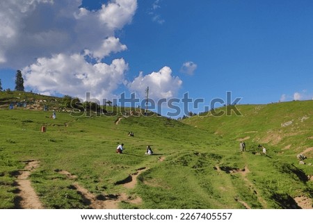 The picture captures the stunning beauty of rolling hills, now adorned with the presence of tourists. The hills appear lush and green, creating a serene and peaceful atmosphere.