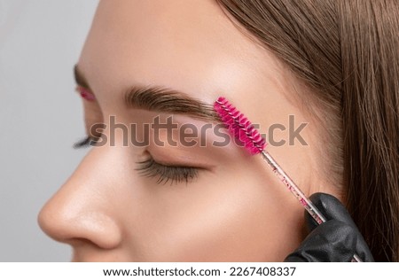 The make-up artist does Long-lasting styling of the eyebrows of the eyebrows and will color the eyebrows. Eyebrow lamination. Professional make-up and face care. Royalty-Free Stock Photo #2267408337