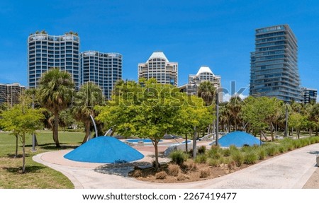 Regatta Park in Miami Beach Florida against apartments and sky on a sunny day. Public recreation area in the city with walkways and trees for visitors and tourists. Royalty-Free Stock Photo #2267419477
