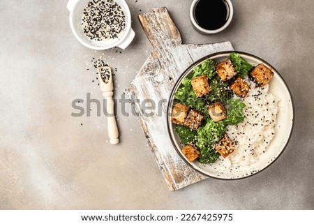 Vegan tofu poke bowl with rice and broccoli on a light background. Clean eating, dieting, vegan food concept. top view.