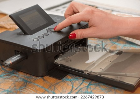 on portable inkjet photo prints - closeup woman hand operated printer