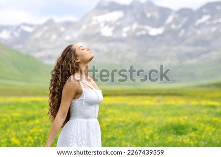 Profile of a woman in white dress breathing in a valley Royalty-Free Stock Photo #2267439359