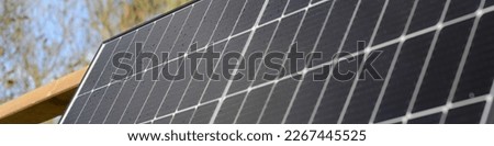 closeup of solar installation with new black roofing solar panel on the roof as a banner background for renewable green energy
