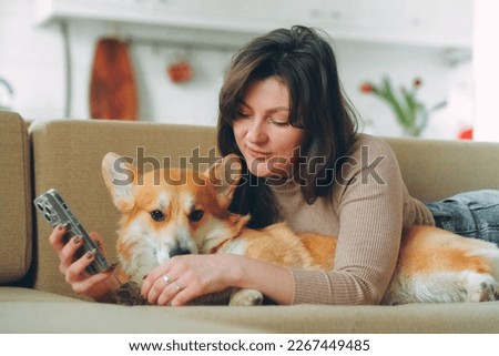 Owner female woman young girl playing with her dog welsh corgi pet . High quality photo