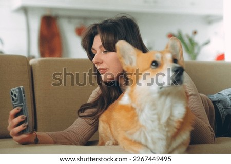 Owner female woman young girl taking selfie photo with her dog welsh corgi pet . High quality photo