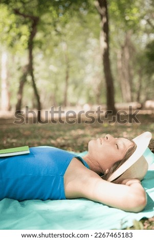 woman reading book and resting in forest