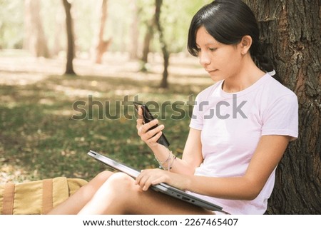 woman in hat in forest with smart phone