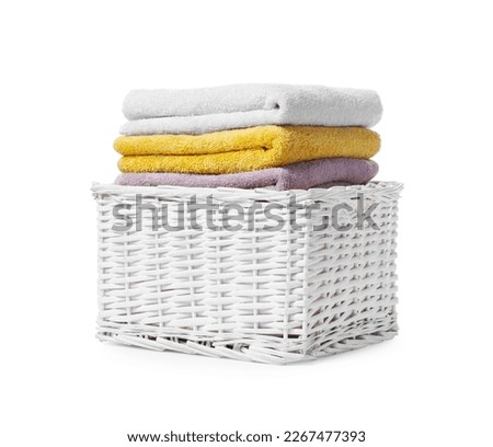 Wicker laundry basket with folded towels isolated on white Royalty-Free Stock Photo #2267477393