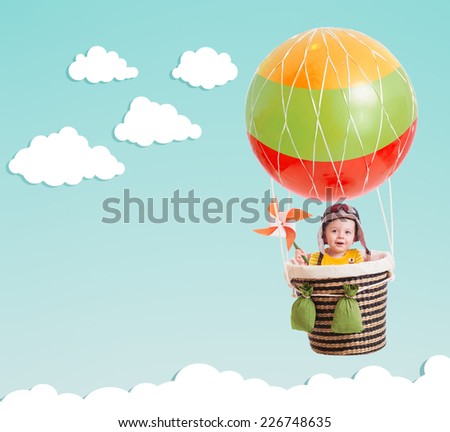 cheerful kid on hot air balloon in the sky