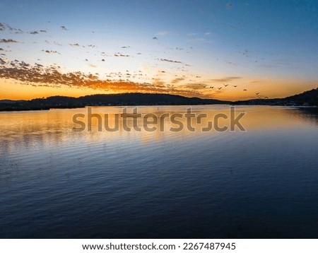 Aerial sunrise over the bay with altocumulus clouds painting the sky at Woy Woy on the Central Coast, NSW, Australia.