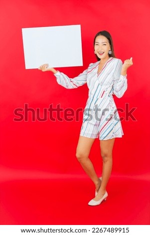 Portrait beautiful young asian woman with empty white billboard on red color