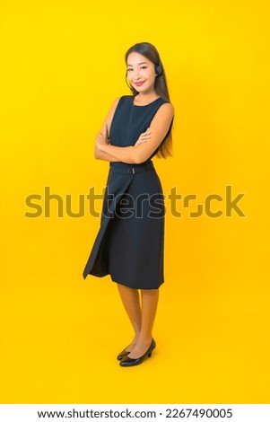 Portrait beautiful young asian business woman with headset call center customer care on yellow background