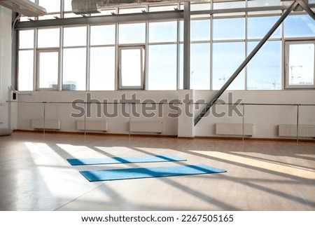 empty hall without people in the morning with sunlight, two yoga mats lie on the floor in the sports room for dancing
