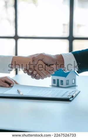 Shaking hands after sign a contract, realtor suggestion a new house model assisting client to sign contract agreement with insurance to happy living building, concerning mortgage loan offer