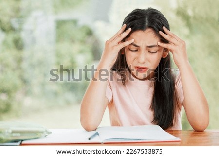 Stress, anxiety and worry with a little girl struggling with her studies, education and learning at home. Confused, frustrated and upset student having trouble with homework and difficult study Royalty-Free Stock Photo #2267533875