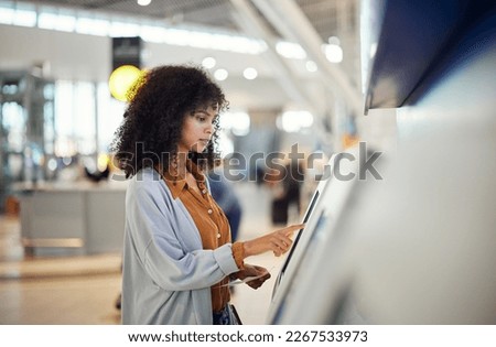 Black woman, airport and self service station for ticket, registration or online boarding pass. African American female traveler by terminal machine for travel application, document or booking flight Royalty-Free Stock Photo #2267533973