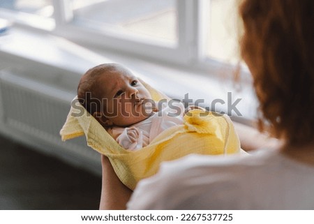 Portrait of happy mum holding infant child on hands. Loving mom carying of her newborn baby at home. Mother hugging her little 1 months old girl. Royalty-Free Stock Photo #2267537725