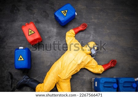 Accident at chemical factory. Worker in protective suit and gas mask lying down unconscious due to suffocation poisoning of toxic chemicals. Royalty-Free Stock Photo #2267566471