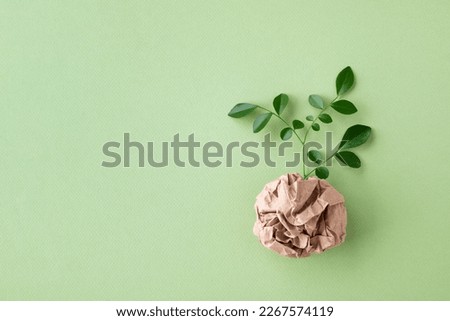 Eco, zero waste, plastic free and saving energy minimal concept from sprout with green leaves growing from recycled craft paper top view. Royalty-Free Stock Photo #2267574119