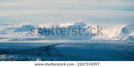 The snow-capped mountain stands tall against a clear blue sky, its jagged peaks and pristine snow reflecting the beauty and power of nature Royalty-Free Stock Photo #2267574397