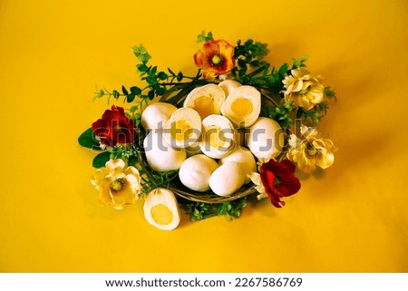 Easter picture with handmade Eggs on a yellow background in a basket with flowers. Spring Mood. Baking in the form of Easter Eggs is an interesting alternative to Easter cake. Religious holiday.
