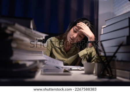 Woman working overtime on a desk at night. Royalty-Free Stock Photo #2267588383