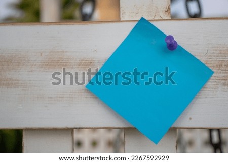 off centre purple map pin blue square paper note on white painted wooden lattice with empty free space for template or blank copy area