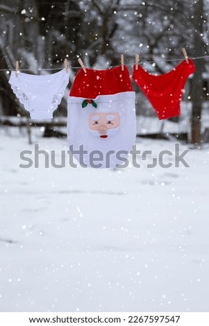 Women's underpants and Santa's Christmas hat are drying on a rope.