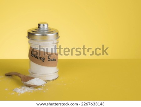 Jar of baking soda with text space against yellow background