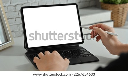 Creative man hand holding stylus pen and pointing on digital tablet screen. Cropped shot Royalty-Free Stock Photo #2267654633