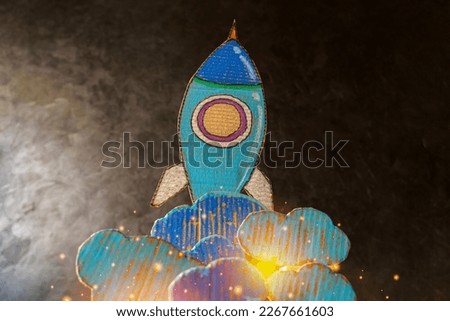 Paper clouds and rockets drawn on cardboard, success and startup concept 3d render.Startup.Rocket Sketch On Blackboard With Colorful Pencils.Back To School