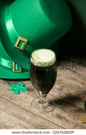 Glass of beer and Leprechaun hats on wooden table. St. Patrick's Day celebration