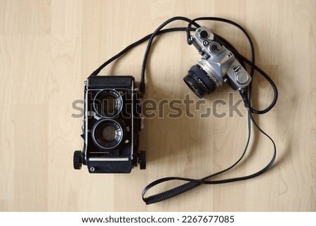 Medium format TLR and 35 mm vintage cameras on a wooden background
