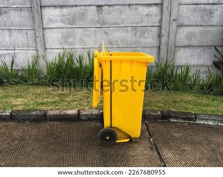 garbage trolley on the side of the road in yellow